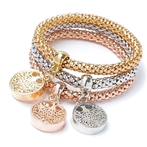 Detailed view of tree of life pendants on gold, silver, and rose gold popcorn chain bracelets