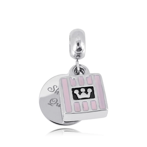 Macro view of silver charm with pink striped shopping bag and engraved metal disc pendant