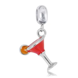 Macro shot of 925 silver cocktail glass charm with red enamel and orange slice detail