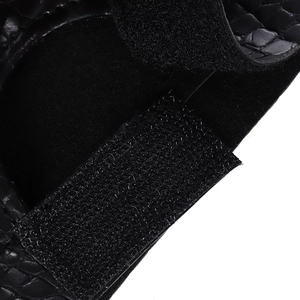 Macro shot of black crocodile leather texture and hook-and-loop closure for dragon claw gloves