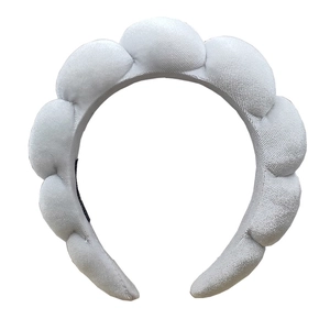Close-up of thick light gray sponge headband with soft terry cloth texture for spa use