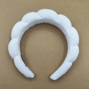 Detail of white sponge puffy headband showing cloud texture and high top volume