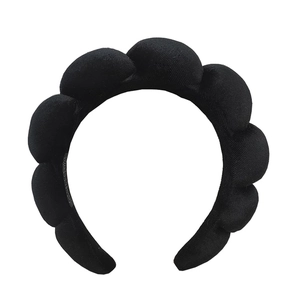 Detail of a thick black padded sponge headband with a soft cloud texture for spa use