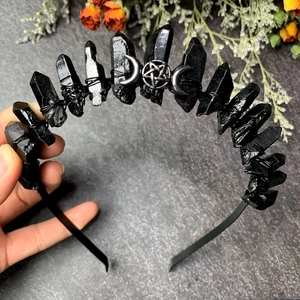 Detail showing handmade black raw stone headband with metal star and moon charms