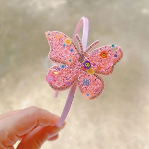 Detailed view of pink butterfly headband decorated with rhinestones and colorful flower charms
