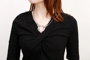Detail of silver double-layered necklace with minimalist circular pendant on model