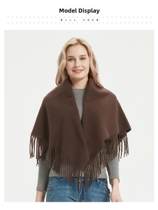 Detail of dark brown scarf with tassel fringe worn with a grey sweater and blue jeans