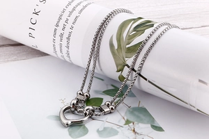 Macro view of double-layer stainless steel box chain with a polished silver heart pendant