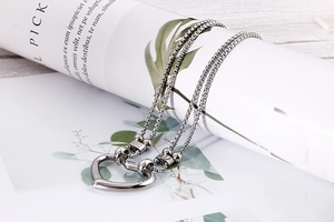 Detail view of silver double-layered box chain necklace with a heart pendant