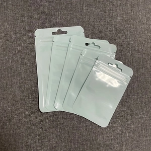 Detailed view of white plastic self-sealing bags with hanging holes on grey fabric