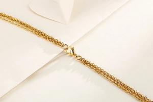 Detailed macro view of the gold lobster clasp and multi-layer chain link structure