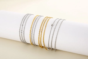 Close-up of gold and silver stainless steel layered chains with small bead accents