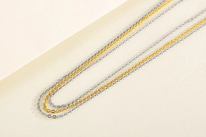 Detailed view of triple-layered gold and silver minimalist stainless steel chain necklaces