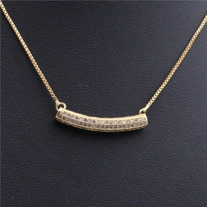 Elegant gold-tone copper necklace featuring a curved bar pendant with micro-set zircon stones