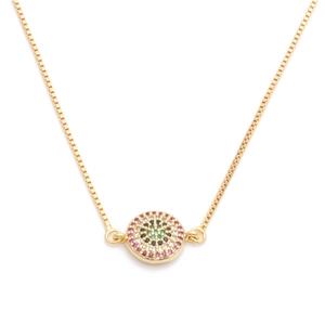 Close-up of a gold-plated necklace with a round pendant set with colorful zircon stones