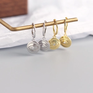 Macro shot of silver and gold S925 sterling silver evil eye hoop earrings with zircon