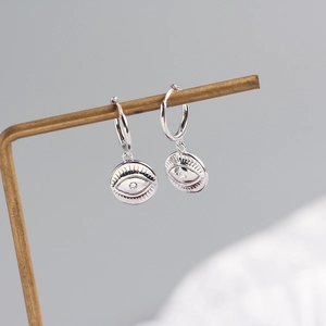 Detailed close-up of S925 sterling silver hoop earrings with evil eye totem pendants