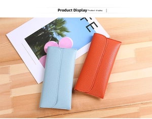 Close-up of light blue and orange lychee pattern leather long wallets on wood background