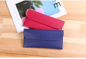 Detailed top view of rose pink and navy blue lychee textured long leather wallets