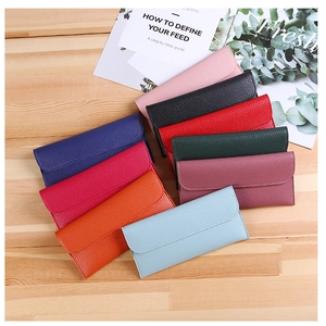 Litchi pattern faux leather wallets in multiple colors displayed on a wooden table