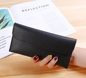 Macro shot of black litchi pattern leather wallet texture and long slim design