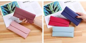 Litchi pattern long wallets in multiple vibrant colors on a wooden background
