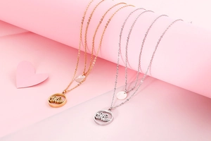 Close-up of gold and silver double-layered stainless steel necklaces with Mum pendant