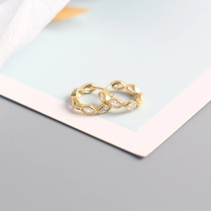 Macro shot of gold S925 silver hoop earrings featuring marquise-cut sparkling crystals