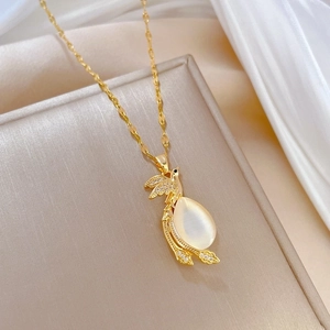 Elegant gold phoenix necklace with teardrop cat-eye stone and crystal accents on silk