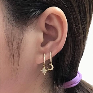 Gold star and crescent moon hoop earrings with cubic zirconia stones on model