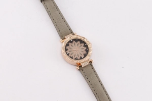 Detailed macro view of the rose gold quartz watch with a grey leather strap and floral dial