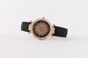 Detail of rose gold watch face featuring a floral pattern and rhinestone embellishments
