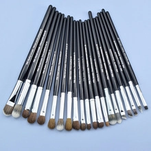 Detail shot of a professional makeup brush set with silver ferrules on blue background