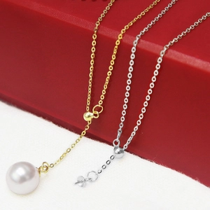 Macro shot of gold and silver S925 sterling silver necklaces with glossy white pearl pendant