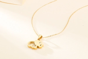 Detail of gold elephant pendant with small crystal on a dainty titanium steel chain