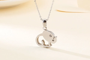Close-up of silver hollow elephant pendant necklace with a small diamond and O-chain