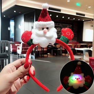 Macro view of plush red Santa Claus headband with LED lights and festive sequins