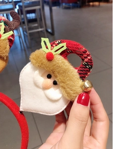 Detail of Christmas headband with Santa plush, red velvet fabric and gold bell accent