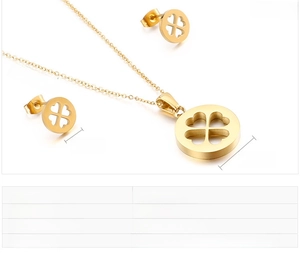 Détails macro d'un ensemble de bijoux trèfle en acier doré avec collier et boucles d'oreilles
