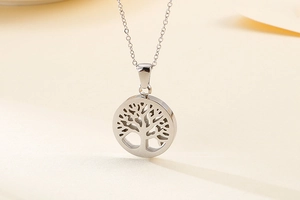 Macro shot of silver tree of life cutout pendant on a polished stainless steel chain