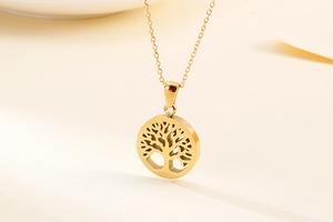 Detailed close-up of a gold Tree of Life hollow pendant on a titanium steel necklace