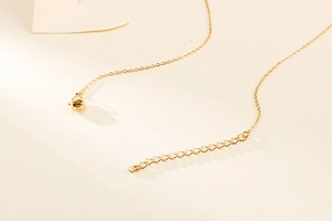 Detail view of the gold tree of life necklace showing the extension chain and lobster clasp