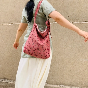 Detail of pink corduroy tote bag with red floral print and adjustable tie shoulder strap
