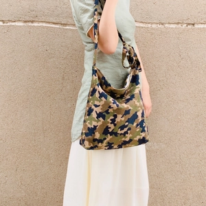 Detail view of camouflage canvas hobo bag with unique knotted shoulder strap design