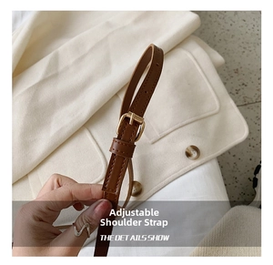 Adjustable brown leather shoulder strap with gold buckle and fine stitching detail