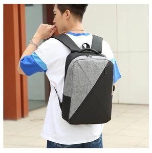 Detail of the black and gray oxford fabric backpack worn by a male model outdoors