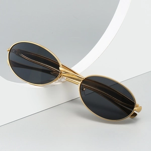 Lunettes de soleil ovales rétro avec monture dorée et verres foncés sur fond d'art