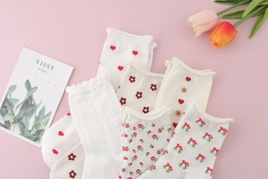 Detail of sweet cotton mid-calf socks with ruffled edges and cute cherry heart patterns