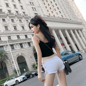 Dettaglio degli shorts in denim bianco con orlo sfrangiato e cerniera metallica laterale