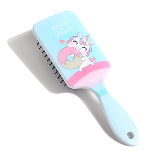 Detail of light blue cartoon unicorn paddle brush with Enjoy Dream lettering and hang hole